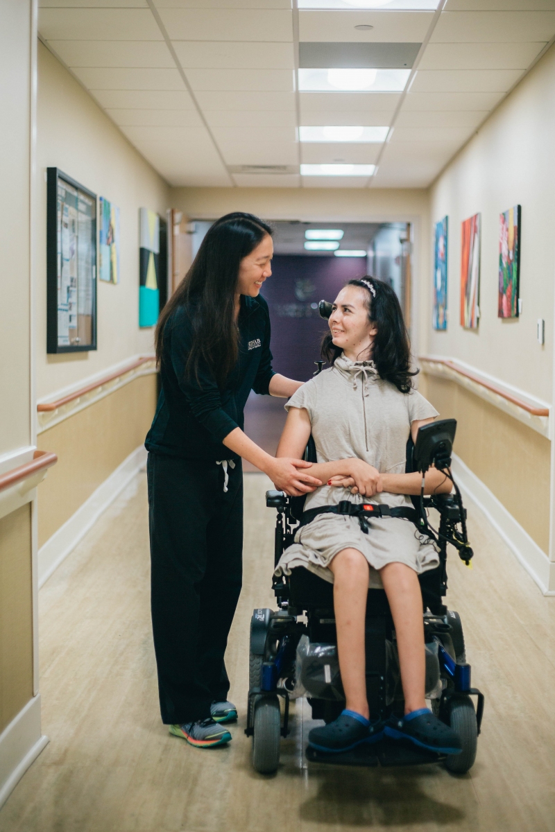 Rehab staff member assisting spinal cord injury patient