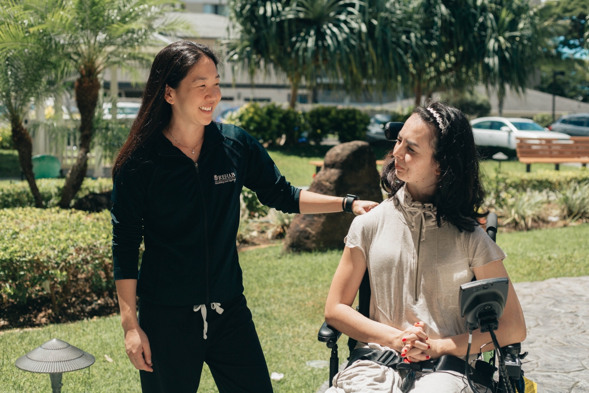 Rehab staff member talking with spinal cord rehabilitation patient