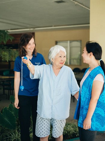 2 volunteers helping an elderly woman